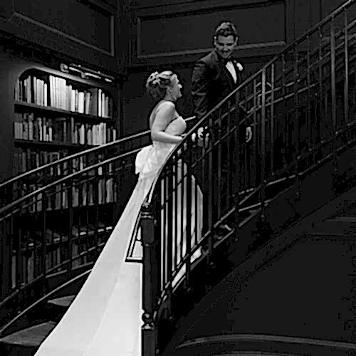 bride and groom on library staircase